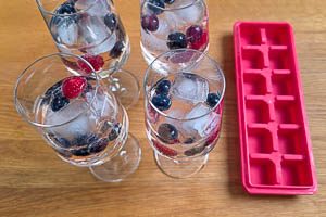 Beeren, Eisw&uuml;rfel und Minze ins Glas geben