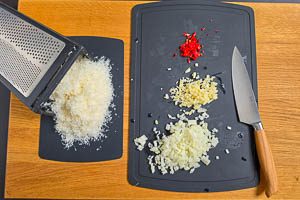 Zwiebel, Knoblauch und Peperoni schneiden, Parmesan fein reiben