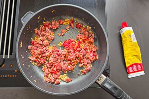 Knoblauch dazugeben und mit Tomatenmark anbraten