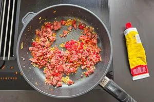 Knoblauch dazugeben und mit Tomatenmark anbraten