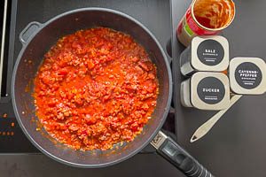 St&uuml;ckige Tomaten dazugeben und dann mit Salz, Cayennepfeffer und Zucker abschmecken