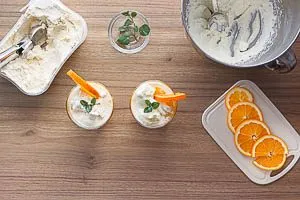 Vanilleeis ins Glas geben und mit etwas Minze und Orangenscheiben dekorieren.