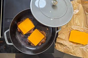 Käse auf die Patties, dann jeweils noch ein Patty darauf stapeln und mit Käse topppen