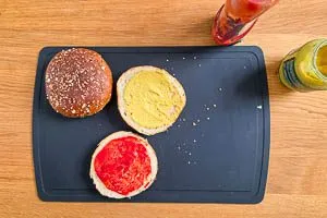 Buns erw&auml;rmen, zerschneiden, eine Seite mit Ketchup und eine Seite mit Senf bestreichen