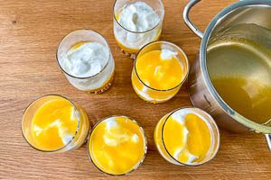 Fruchtpudding und Creme abwechselnd in die Dessertgl&auml;ser schichten