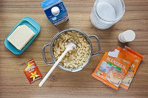 Für das Topping Butter, Zucker, Bourbon-Vanillezucker, Salz und Milch im Kochtopf köcheln lassen und die Mandelblättchen dazugeben