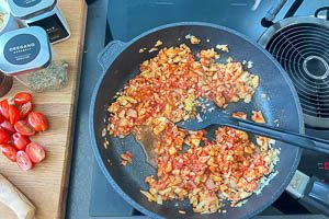 Zwiebel und Knoblauch in der Pfanne anbraten und weitere Zutaten hinzugeben