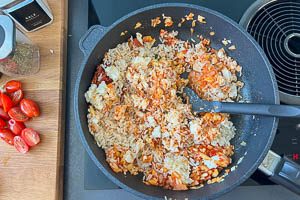 Reis in die Pfanne zu den aromatisch angebratenen Zutaten geben