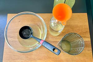 Holunderblütensaft in sterilisierte Flaschen abfüllen