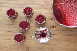 Marmelade durch einen Trichter in die Schraubgläser füllen