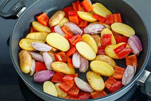 Kartoffeln, Paprika und Schalotten in Olivenöl anbraten