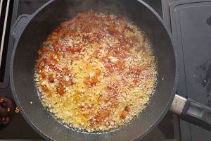 Zwiebel- und Knoblauchw&uuml;rfel in die Pfanne geben