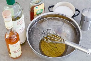 Das Dressing f&uuml;r den Tomatensalat aus &Ouml;l, Essig, Honig, Salz und Pfeffer anr&uuml;hren.