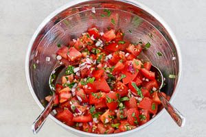 Zwiebeln und Petersilie mit den Tomaten und dem Salat vermischen.