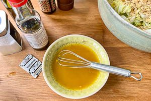 Gepresste Knoblauchzehe, Instantnudel-W&uuml;rzmischung, Salz, Wasser, &Ouml;l, Essig, Zucker und schwarzen Pfeffer f&uuml;r das Dressing zusammenr&uuml;hren