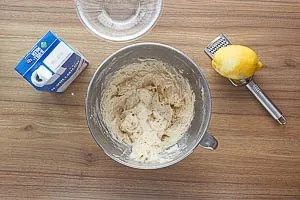 Zitronenabrieb und Milch zur Mehl-Mischung geben