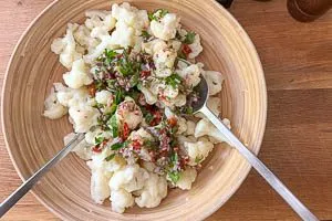 Dressing, frische Zutaten und Blumenkohl zusammengeben.