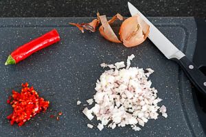 Zwiebel und Peperoni in W&uuml;rfel schneiden