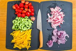 Tomaten, Gurke, Paprika, Zwiebel und Radieschen schneiden