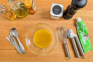 Dressing aus Oliven&ouml;l, wei&szlig;em Balsamico, Wasser, Honig, Senf, Knoblauch, Salz und Pfeffer zubereiten