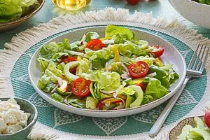Gemischten Salat mit Dressing vermengt servieren