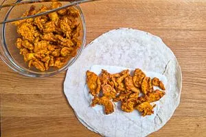 H&auml;hnchenfleisch auf der Knoblauchso&szlig;e verteilen