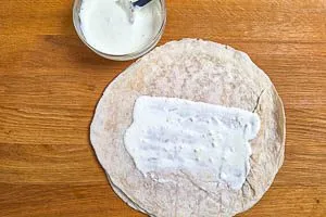 Knoblauchso&szlig;e auf einem Wrap verstreichen