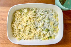 Kohlrabi- und Kartoffelw&uuml;rfel in die Auflaufform geben, mit So&szlig;e &uuml;bergie&szlig;en und mit K&auml;se bestreuen