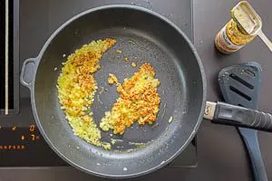 Körnigen Senf zu den Zwiebeln geben.