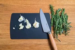 Knoblauchzehen zerdr&uuml;cken und Rosmarin waschen