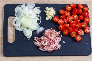 Zwiebeln, Knoblauch, Bacon und Tomaten klein schneiden.