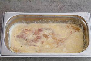 Bemehltes Schnitzel in der Eier-Mischung wenden
