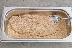 Schnitzel in das Paniermehl geben und dieses leicht verteilen