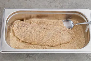 Schnitzel in das Paniermehl geben und dieses leicht verteilen