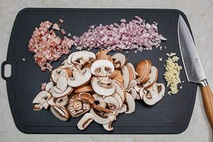 Schalotten, Knoblauch, Champignons und Bauchspeck schneiden