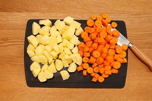 Kartoffeln und Möhren klein schneiden