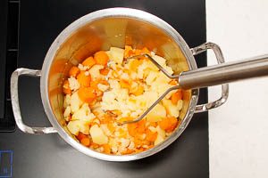 Kartoffeln und Möhren zerstampfen
