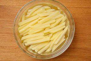 Pommes in kaltem Wasser einlegen.