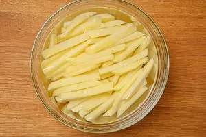 Pommes in kaltem Wasser einlegen.