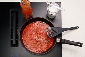 Passierte Tomaten dazugeben, mit Salz und Zucker würfen