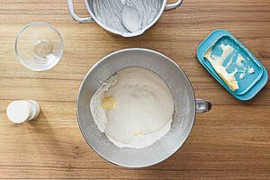 &Uuml;briges Mehl, Zucker, Salz und Butter mit der Hefemischung in eine R&uuml;hrsch&uuml;ssel geben