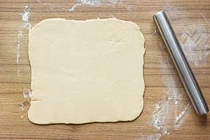 Hefeteig mit einem Nudelholz aufrollen