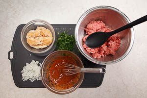 Hackfleisch, Zwiebeln, Petersilie, EI-Masse und ausgedr&uuml;cktes Br&ouml;tchen in eine Sch&uuml;ssel geben