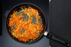 Knoblauchw&uuml;rfel zum Gem&uuml;se in die Pfanne geben