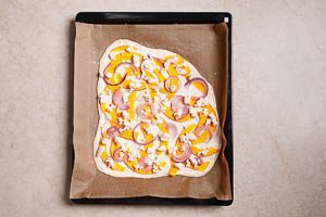 Flammkuchen mit K&uuml;rbis-Topping in den Ofen schieben