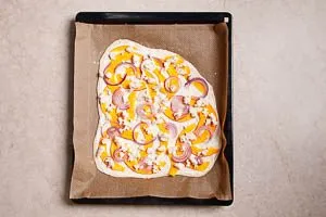 Flammkuchen mit K&uuml;rbis-Topping in den Ofen schieben