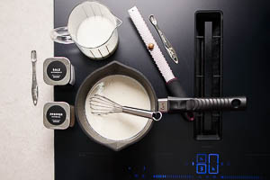 Milch f&uuml;r die Sauce in den Topf geben und w&uuml;rzen