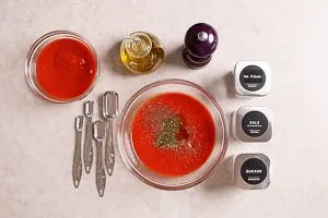 Passierte Tomaten mit Olivenöl, Kräutern und Gewürzen verrühren