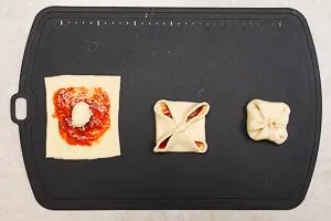 Bestrichene Pizzateig-Quadrate zu Brötchen formen