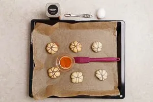 Rohe Pumpkin-Pizzabrötchen mit gewürztem Ei bepinseln
